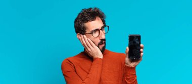 Genç, deli, sakallı, kafası karışık bir adam. akıllı telefon kavramı