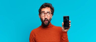 Genç, deli, sakallı, kafası karışık bir adam. akıllı telefon kavramı