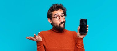 Genç, deli, sakallı, kafası karışık bir adam. akıllı telefon kavramı