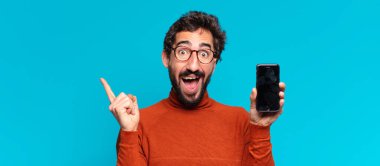 Genç, deli, sakallı adam. Zaferi kazanan gibi kutluyoruz. akıllı telefon kavramı