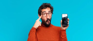 Genç, deli, sakallı adam. Düşünen ya da şüphe eden bir ifade. akıllı telefon kavramı