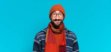 Genç, deli, sakallı adam. Mutlu ve şaşırmış bir ifade ve kışlık kıyafetler.