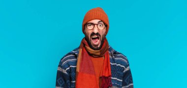 Genç çılgın sakallı adam ve kışlık kıyafetler giyiyor.