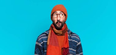 Genç, deli, sakallı adam. Şok olmuş ya da şaşırmış bir ifade ve kışlık kıyafetler.