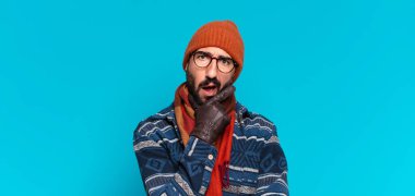 Genç, deli, sakallı adam. Düşünmek ya da şüphe etmek ve kışlık giysiler giymek