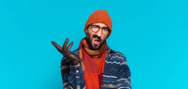 Genç çılgın sakallı adam ve kışlık kıyafetler giyiyor.