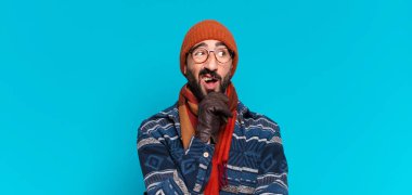 Genç, deli, sakallı adam. Düşünmek ya da şüphe etmek ve kışlık giysiler giymek