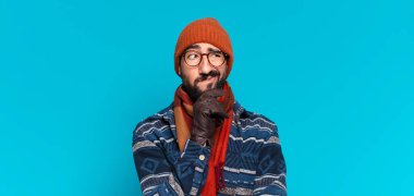 Genç, deli, sakallı adam. Düşünmek ya da şüphe etmek ve kışlık giysiler giymek