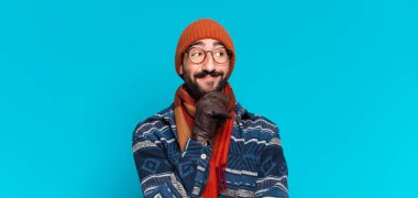 Genç, deli, sakallı adam. Düşünmek ya da şüphe etmek ve kışlık giysiler giymek