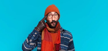 Genç, deli, sakallı adam. Düşünmek ya da şüphe etmek ve kışlık giysiler giymek