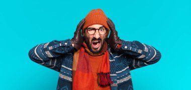 Genç çılgın sakallı adam ve kışlık kıyafetler giyiyor.