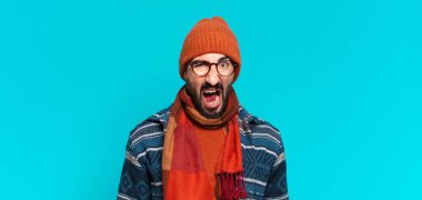 Genç çılgın sakallı adam ve kışlık kıyafetler giyiyor.