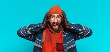 Genç çılgın sakallı adam ve kışlık kıyafetler giyiyor.