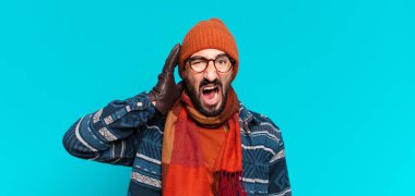 Genç çılgın sakallı adam ve kışlık kıyafetler giyiyor.