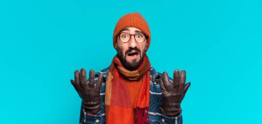 Genç çılgın sakallı adam ve kışlık kıyafetler giyiyor.