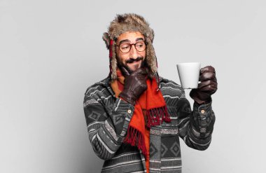 Genç, deli, sakallı adam. Düşünmek ya da şüphe etmek ve kışlık giysiler giymek