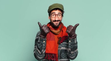 Genç, deli, sakallı adam. Mutlu ve şaşırmış bir ifade ve kışlık kıyafetler.