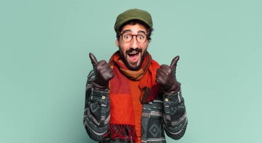 Genç, deli, sakallı adam. Mutlu ve şaşırmış bir ifade ve kışlık kıyafetler.