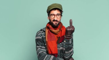 Genç çılgın sakallı adam ve kışlık kıyafetler giyiyor.