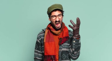 Genç çılgın sakallı adam ve kışlık kıyafetler giyiyor.