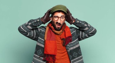 Genç çılgın sakallı adam ve kışlık kıyafetler giyiyor.