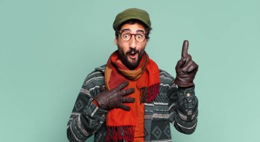 Genç çılgın sakallı adam gururlu bir ifade ve kışlık kıyafetler giyiyor.