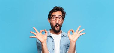 Genç, deli, sakallı adam. Mutlu ve şaşırmış ifade