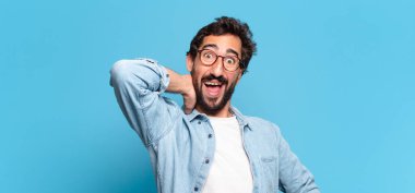 Genç, deli, sakallı adam. Mutlu ve şaşırmış ifade