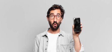 Genç, deli, sakallı adam. Şaşırmış ya da şok olmuş. telefon ekranı kavramı
