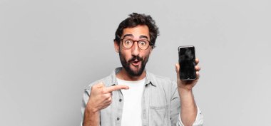 Genç, deli, sakallı adam. İşaret işareti. telefon ekranı kavramı