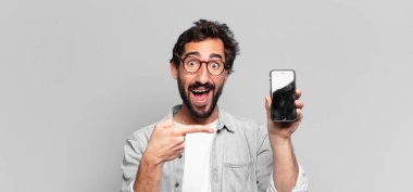 Genç, deli, sakallı adam. İşaret işareti. telefon ekranı kavramı