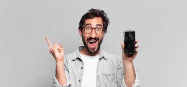 Genç, deli, sakallı adam. Zaferi kazanan gibi kutluyoruz. telefon ekranı kavramı