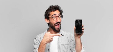 Genç, deli, sakallı adam. Şaşırmış ya da şok olmuş. telefon ekranı kavramı