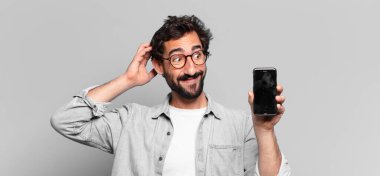 Genç, deli, sakallı adam. Şaşırmış ya da şok olmuş. telefon ekranı kavramı