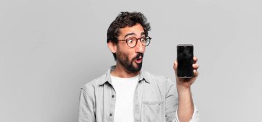 Genç, deli, sakallı adam. Şaşırmış ya da şok olmuş. telefon ekranı kavramı