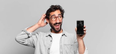 Genç, deli, sakallı adam. Şaşırmış ya da şok olmuş. telefon ekranı kavramı