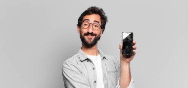 Genç, deli, sakallı adam. Mutlu ve şaşırmış bir ifade. telefon ekranı kavramı
