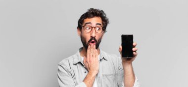 Genç, deli, sakallı adam. Şaşırmış ya da şok olmuş. telefon ekranı kavramı