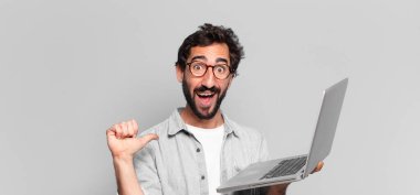 Genç, çılgın, sakallı, gururlu adam ifadesi. dizüstü bilgisayar