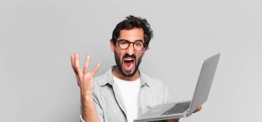 Genç, deli, sakallı adam. dizüstü bilgisayar