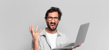 Genç, deli, sakallı adam. dizüstü bilgisayar