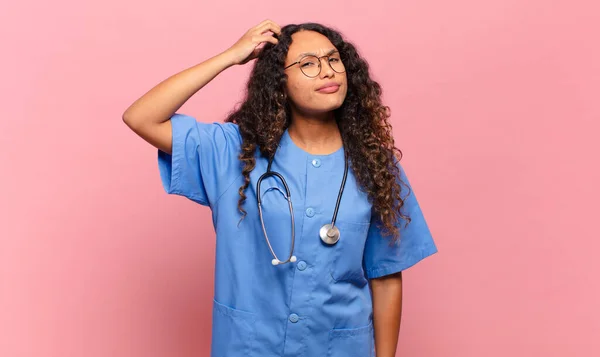 若いヒスパニック系の女性は困惑し 混乱し 頭を引っ掻いて 側を探しています 看護師の概念 — ストック写真
