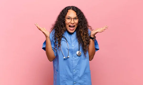 若いヒスパニック系の女性は幸せな感じ 驚きやショックを受けました 笑顔と信じられない何かに驚きました 看護師の概念 — ストック写真