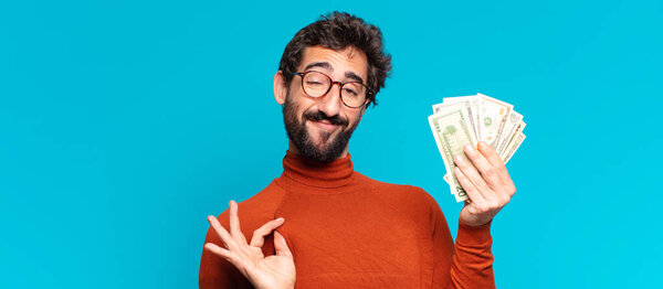 Молодой сумасшедший бородатый мужчина гордится выражением. Концепция долларовых банкнот