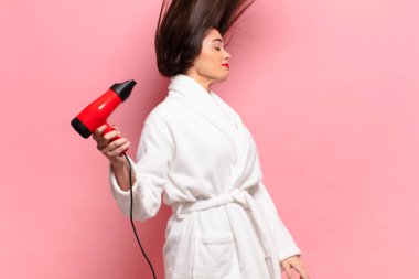 Genç, güzel, İspanyol bir kadın. Mutlu ve şaşırmış bir ifade. saç kurutma makinesi konsepti