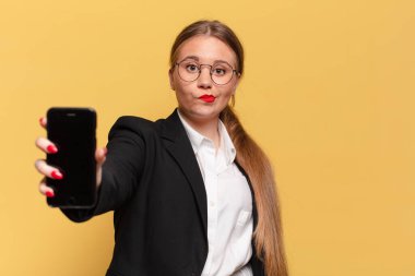 Genç, güzel bir kadın kafası karışık, akıllı telefon konsepti