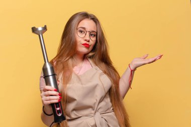 Genç ve güzel bir kadının kafası karışık fırıncı blender konsepti