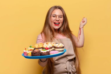 Genç ve güzel bir kadın. Keklerle kazanan bir fırıncı gibi zaferi kutluyoruz.