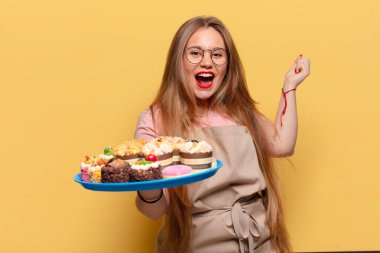 Genç ve güzel bir kadın. Keklerle kazanan bir fırıncı gibi zaferi kutluyoruz.