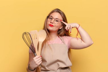 Genç ve güzel bir kadın. Düşünen ya da şüphe eden ifade şefi aşçılık konsepti